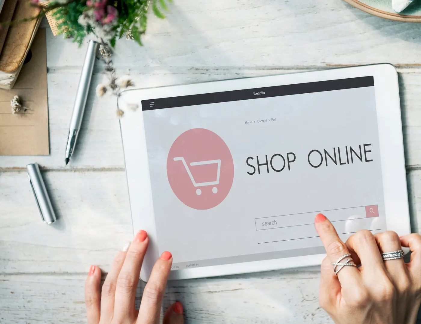 Hands using a tablet that shows an online shop page