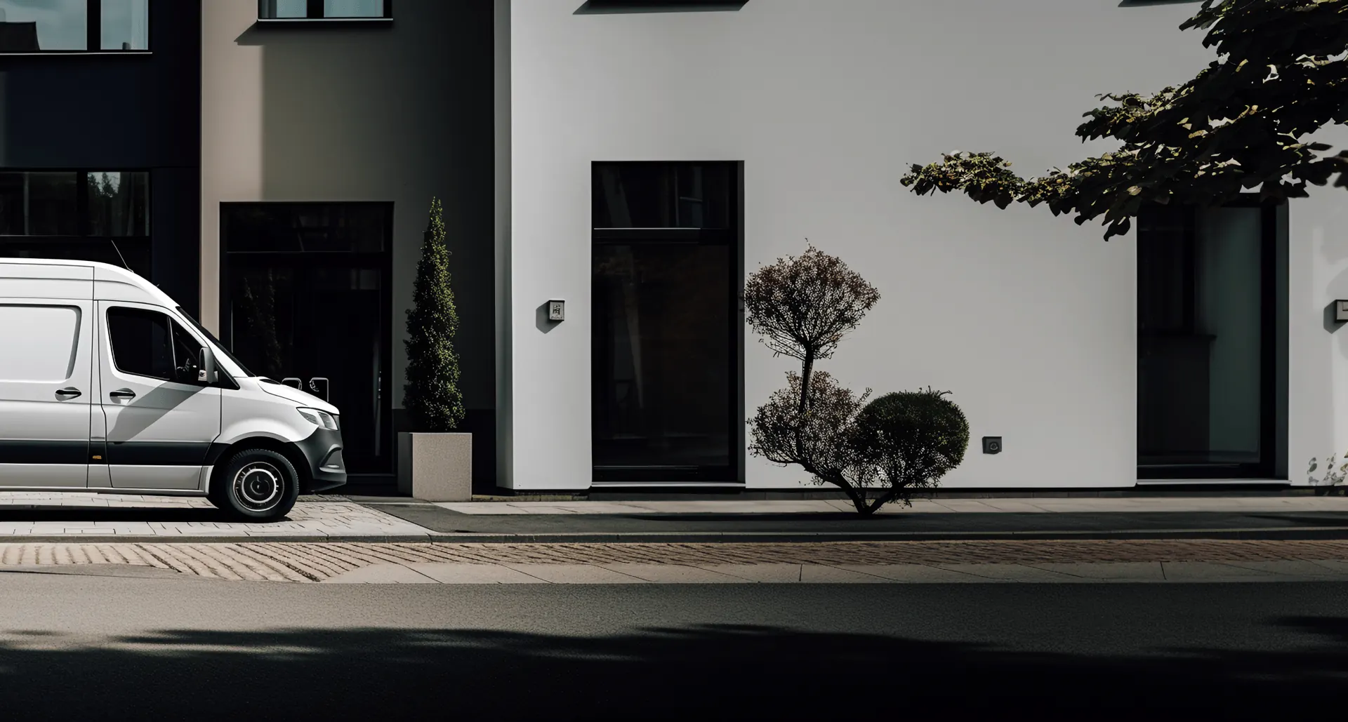 White delivery van parked in front of a modern white building
